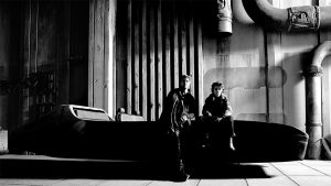 Black and White image, Ryan Gosling and Flynn Gray on set for Star Wars: Starfighter, sitting on some kind of repiulsorlift vehicle. Shot by Ed Miller.